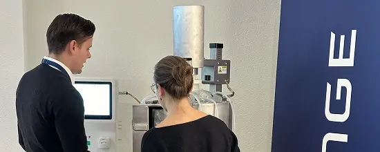 Two guests in conversation at a bioreactor workstation during the break