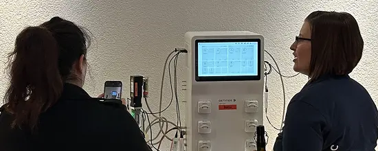 Two participants studying trend curves on a bioreactor controller during a customer talk